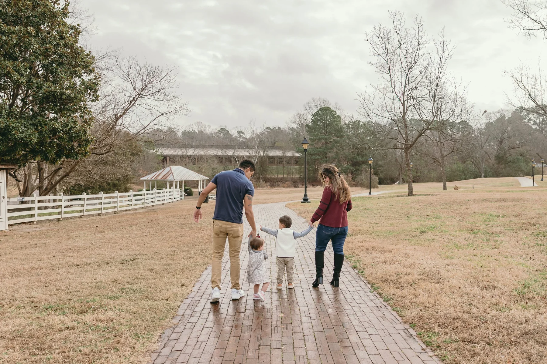 Luisa and her family walking hand-in-hand on a brick path through a park